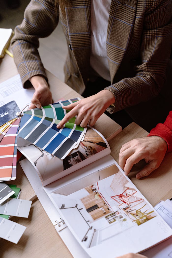 Interior designers discuss color swatches and design ideas at a table, planning a creative project.